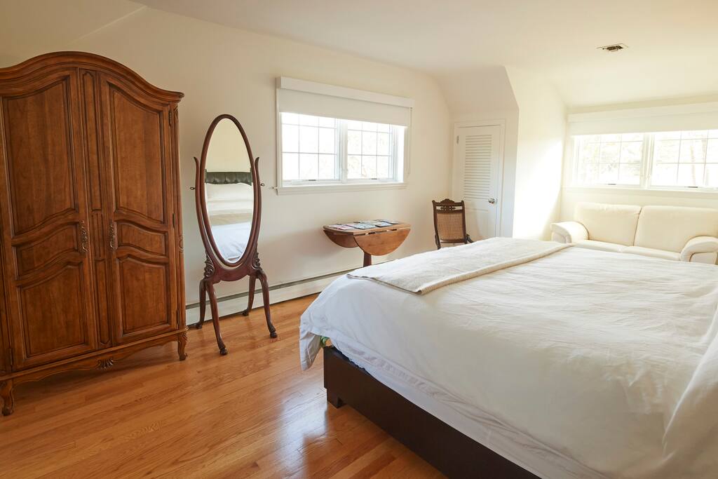 Bedroom 1 has a king size bed, love seat, closet, and private bathroom.