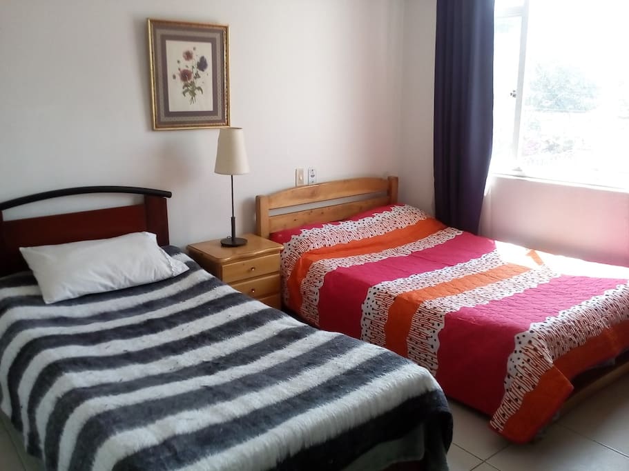 habitación con cama doble y una sencilla, muy acogedora