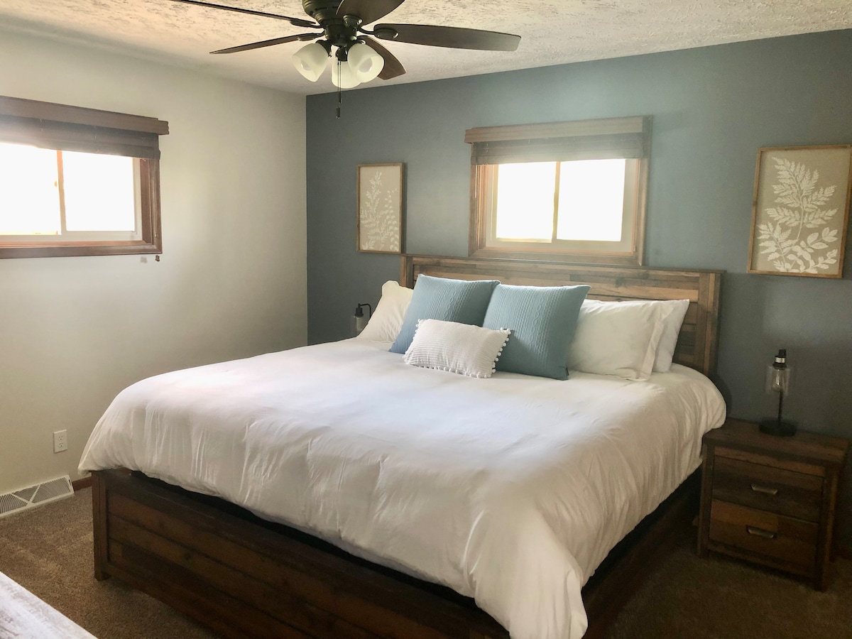 Master Bedroom - Located on the main floor.  King Bed w/ Memory Foam,  Large Closet w/ Hangers, Night Stands, Lamps w/ phone plug ins, Ceiling Fan, Dresser, 55'' Roku TV w/ Netflix!