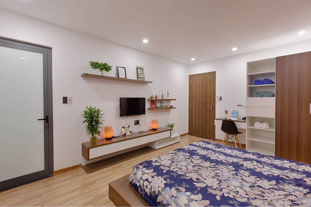 Phòng ngủ chính tầng một với giường cỡ King và phòng tắm riêng.