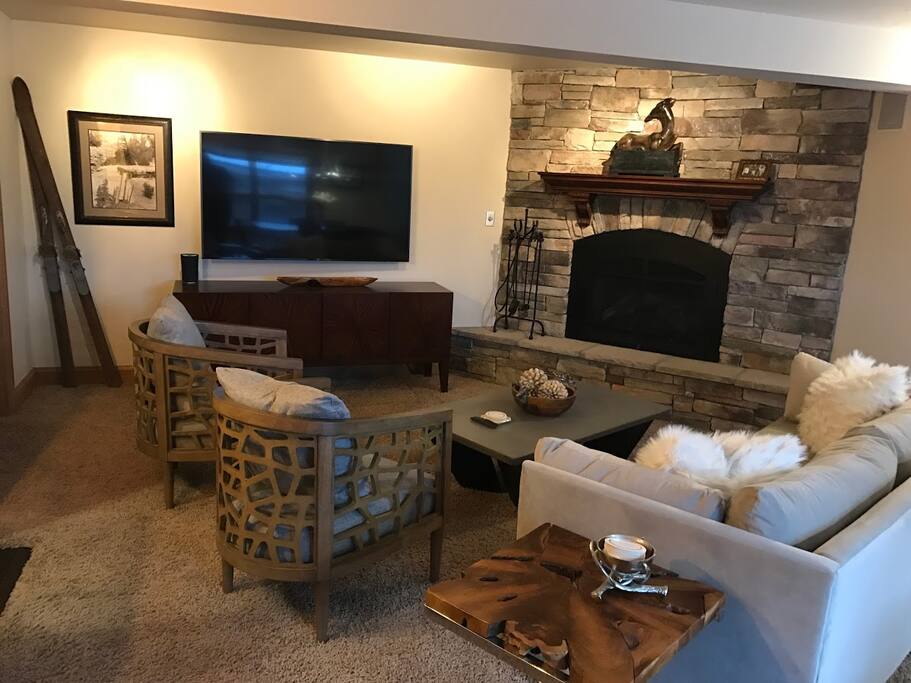 Living Room with Stone Gas Fireplace and 65" TV