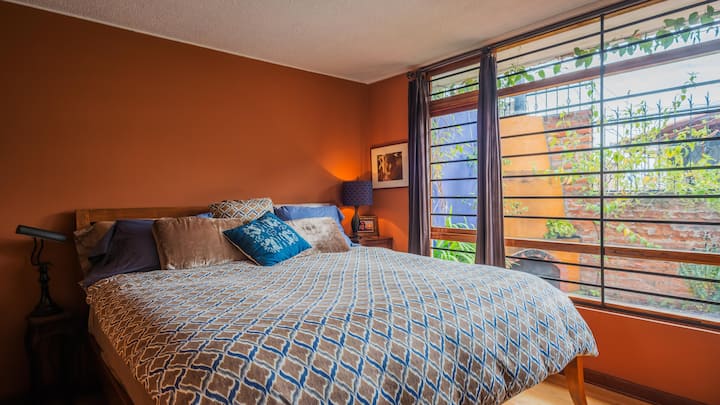¡Dormitorio azul con vista del jardín y chimenea desde la cama con la parte superior acolchada tamaño king!  Incluye TV y reproductor de DVD.