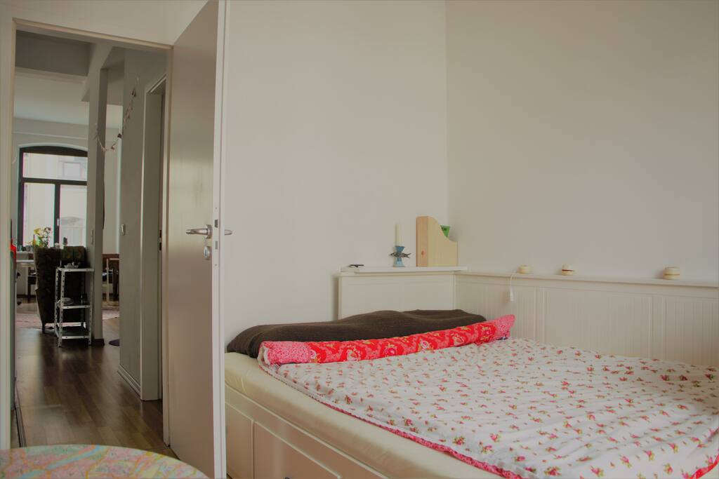 Bett mit Blick in den gemeinschaftlichen Wohnbereich