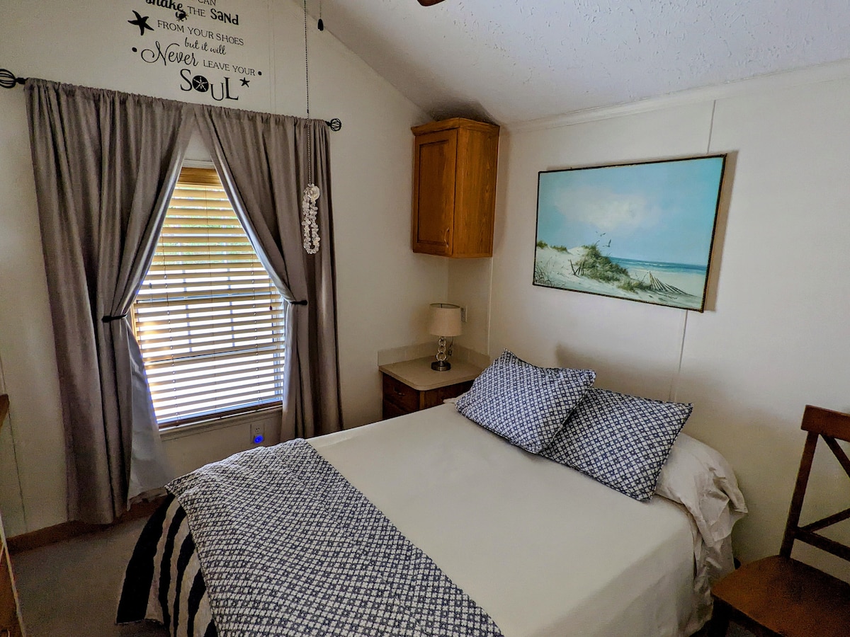 ห้องนอนพร้อมเตียงคู่พัดลมเพดานม่านและที่เก็บของในห้อง