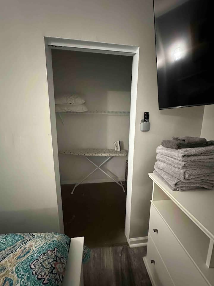 พื้นที่ตู้เสื้อผ้าขนาดเล็กมีโต๊ะรีดผ้าขนาดเต็มและเตารีด