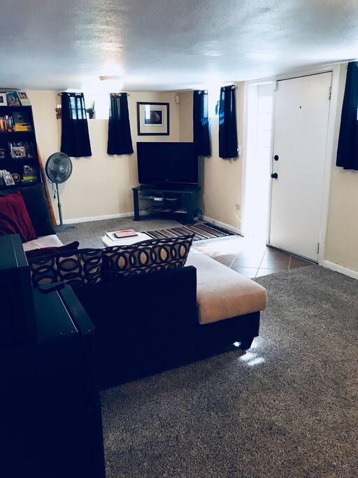 Living area with comfy couch, fridge, microwave, coffee, TV, DVD player and DVDs, Amazon Echo, Chromecast, and plenty of room for air mattress (provided along with extra sheets, pillows, and blankets).
