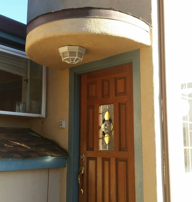 Entrance to cozy stucco and wood duplex.