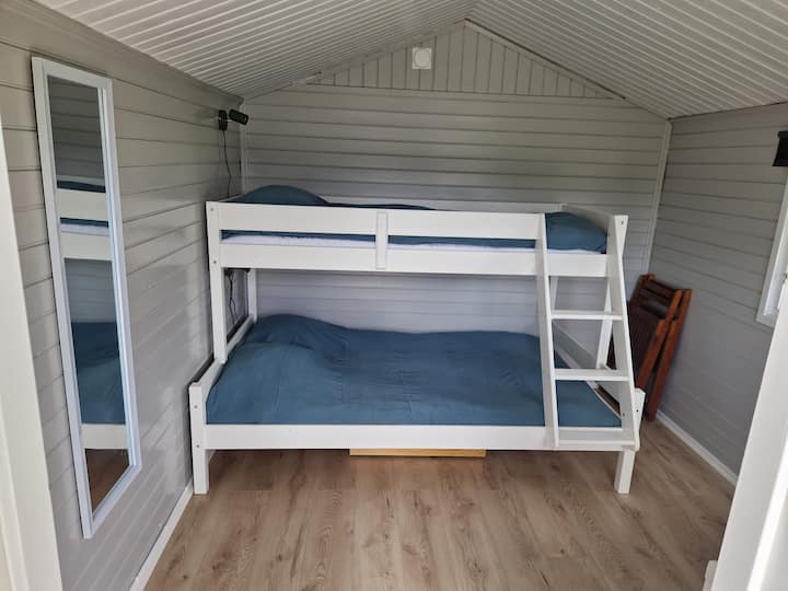 Seoska kućica za goste s krevetom na kat od 120 cm i krevetom od 80 cm na vrhu. 

U gostinjskoj kući postoje elementi koje možete povezati ako je potrebno.