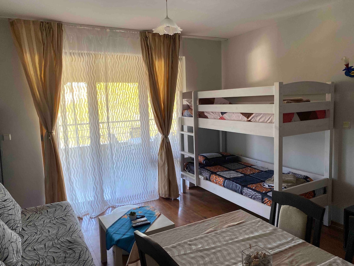 ห้องนั่งเล่นพร้อมโซฟาแบบยืดได้และเตียงสองชั้น