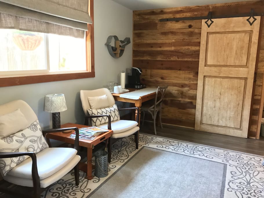 Sitting area, table and chair, barn door entry.
