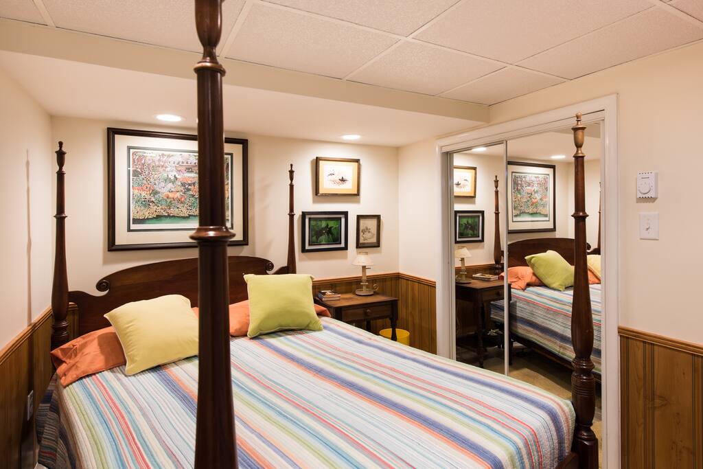 Bed, nice art, mirrored closet and dresser in cubicle