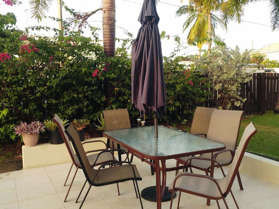 Private large and sunny patio with chairs, table and umbrella