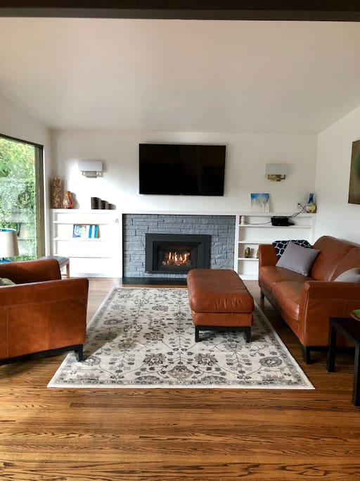 Living room on main floor with gas fireplace. Floor to ceiling windows with sliding doors that lead to the back deck. Lots of natural light.