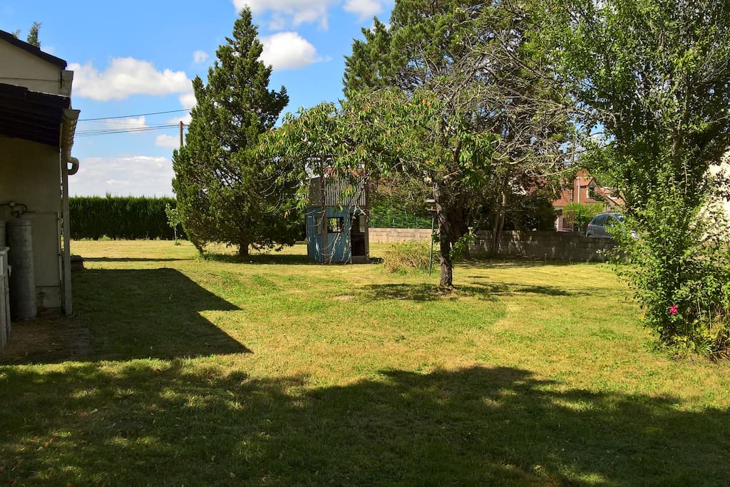 Le jardin arboré avec sa petite cabane et balançoire