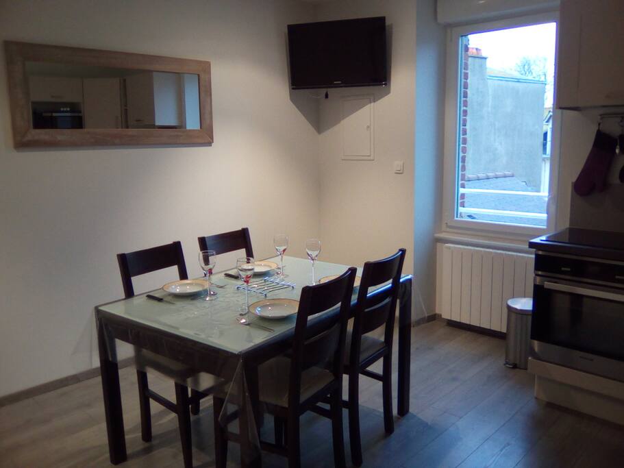 pièces de vie avec grande table et 6 chaises, écran plat, coin canapé.