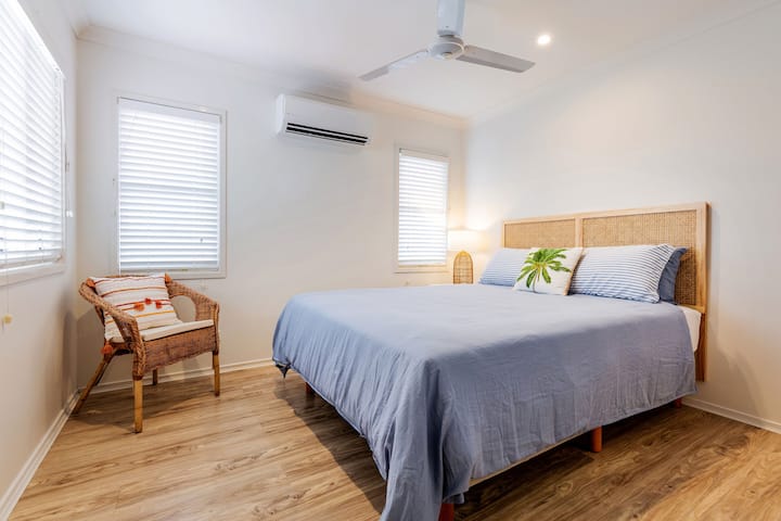 The first bedroom features a queen bed and direct access to the bathroom, plus a ceiling fan and air conditioning to ensure a comfortable nights' sleep.