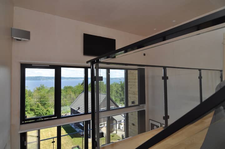 Utsikten från loftet. TV: n är perfekt placerad för visning från sängen på övervåningen, medan båtarna i sjön passerar under genom fönstret.