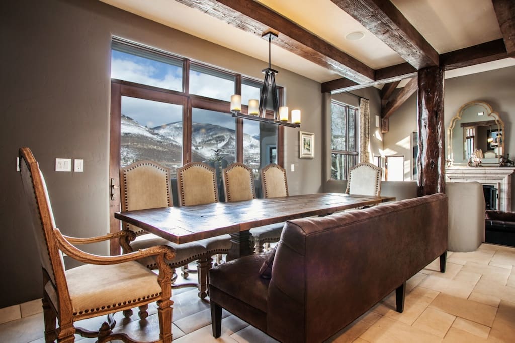 Located next to the kitchen, large dining table for 10 with oversized bench seating and gorgeous mountain views.