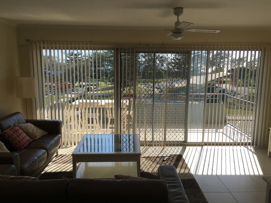 Open plan dining area and lounge with balcony overlooking the park and beach