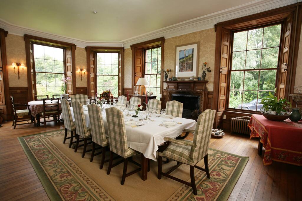 Dining room with 2 tables seating 20 people. A large fireplace
