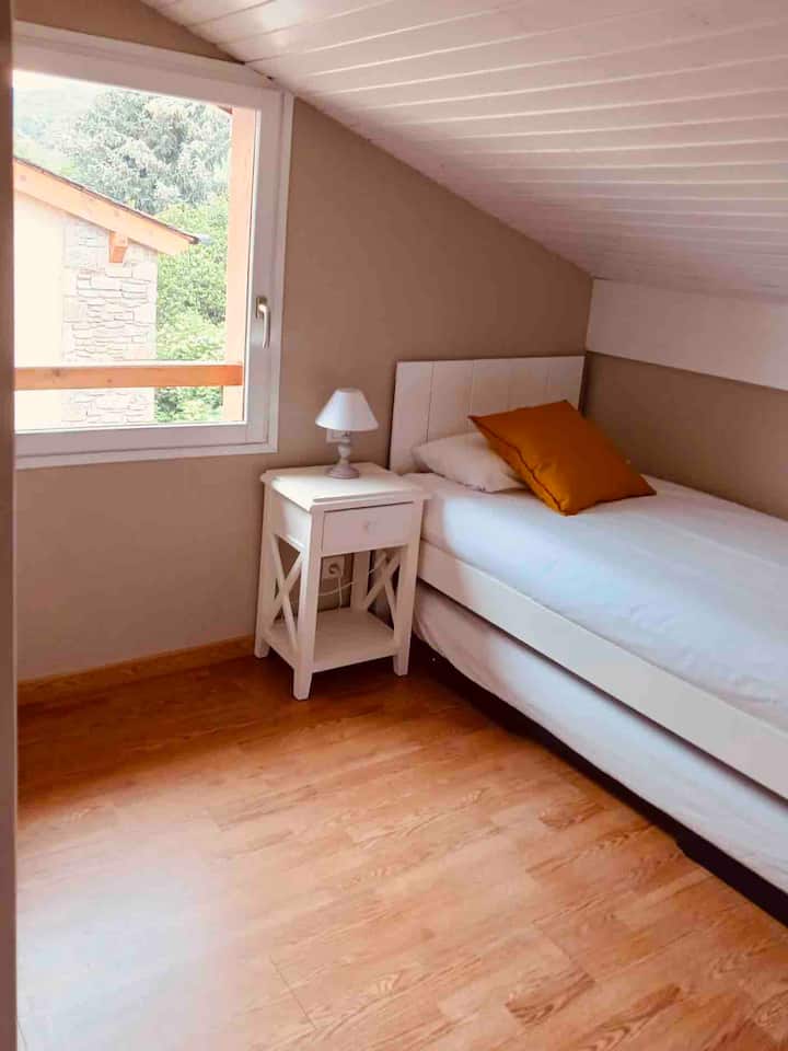 Spavaća soba s 2 kreveta za jednu osobu i vanjskim svjetlom.