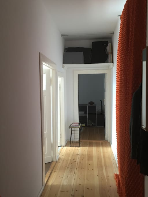 Long corridor with closet, storage, chair, table and hall stand.
