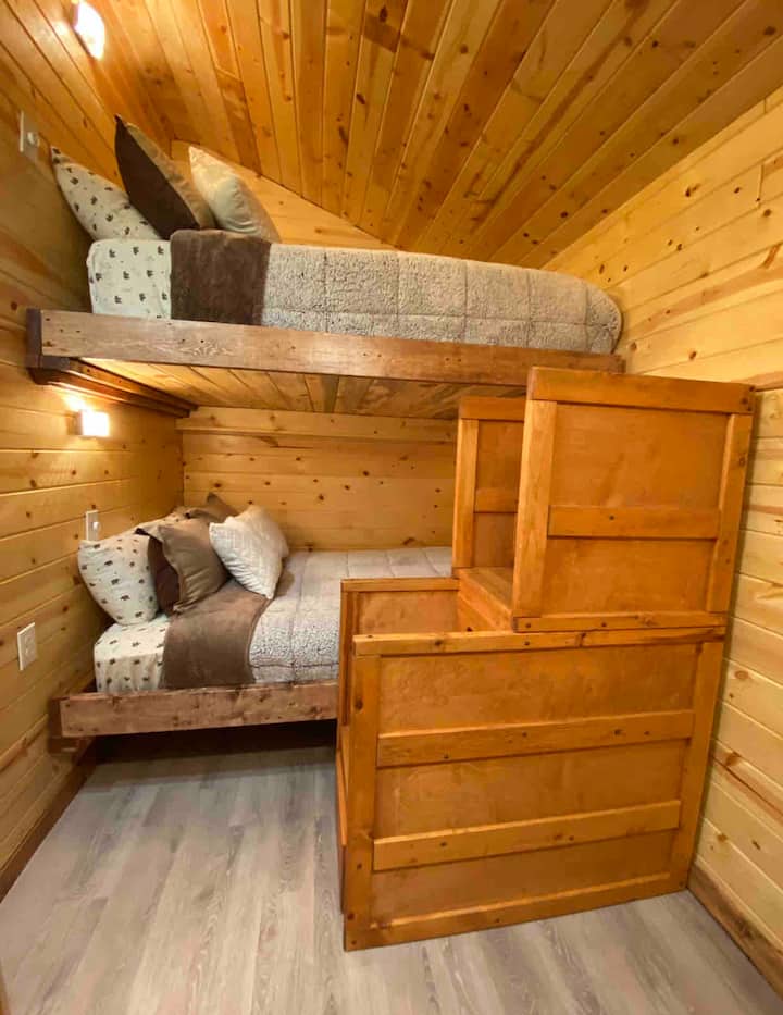 Mala spavaća soba s dva bračna kreveta i ormarom. 