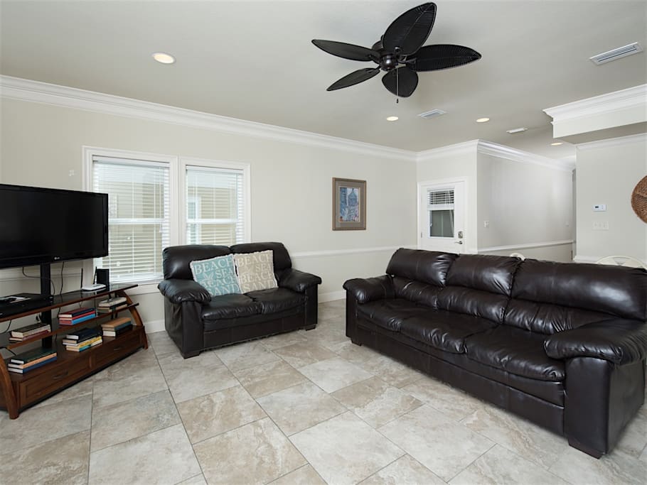 Relax on the comfortable black leather couches in the living room