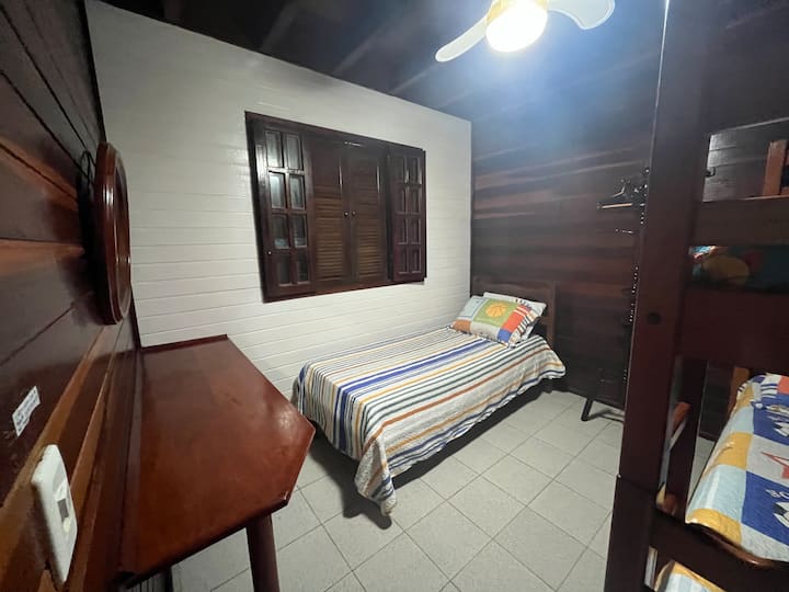 ห้องนอน 3 ที่ชั้นแรกมีเตียงเดี่ยวเตียงสองชั้นกระจกและตู้ข้างเตียงพัดลมเพดานและชั้นวางของ 