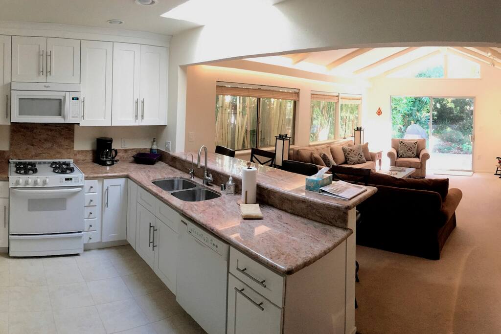 Kitchen opens to the living room and view of backyard oasis.