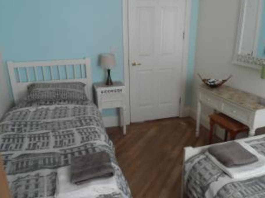 Second bedroom with two singles, dressing table, wardrobe, bed side tables and lamps