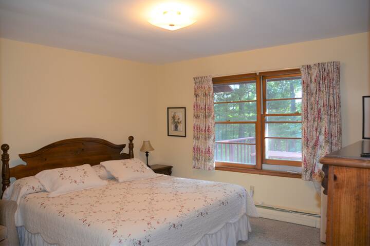 חדר שינה עם מיטת קינג סייז, שידה, טלוויזיה ומיזוג אוויר.