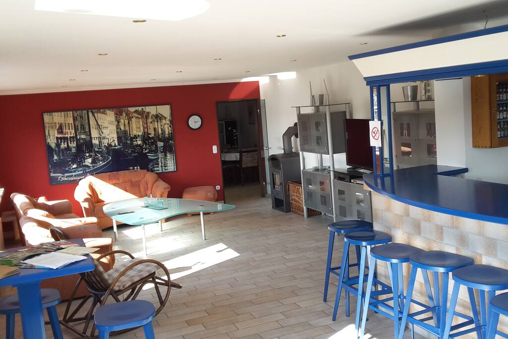 Unser großes Wohnzimmer mit Kaminofen, Theke und Balkon