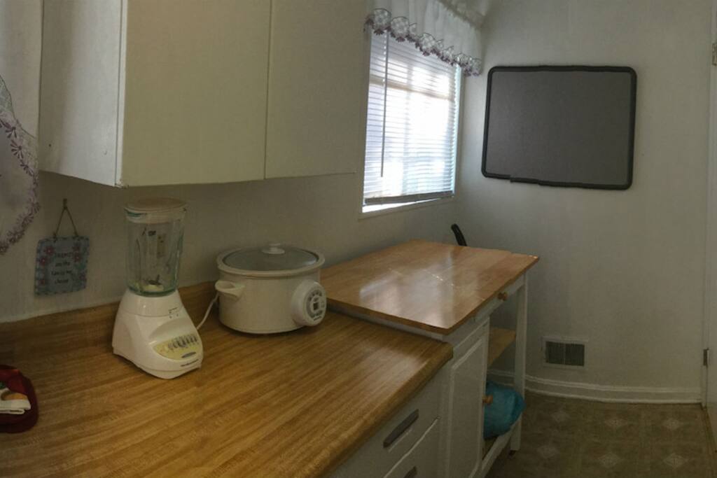 Galley Kitchen with Dishware, full stove, Microwave, Cookware.