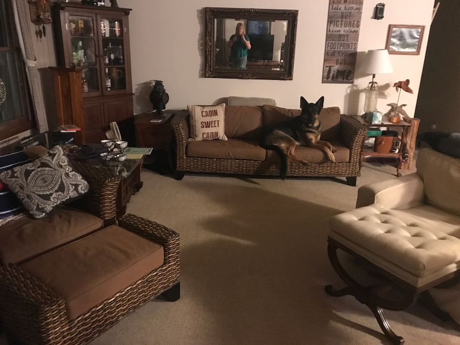 Living room. When using the ottomans as chairs can seat 11. Front deck accessible from here. Yes, that’s me in the mirror.