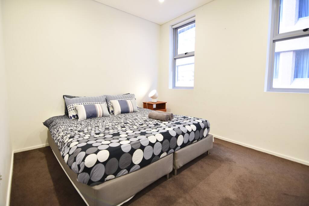 A bedroom with a king sized bed & plush pillows.