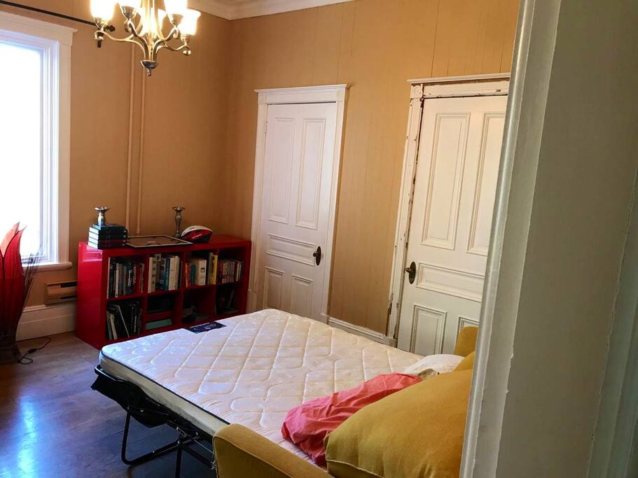 Chambre avec divan-lit et salle de bain privée.