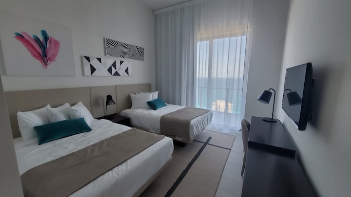 Druhá spálňa s 2 veľkými posteľami, stolom na notebook a prístupom na balkón s výhľadom na oceán.

Habitacion secundaria con 2 camas plná veľkosť escritorio de laptop y acceso al balcón con vista al mar.