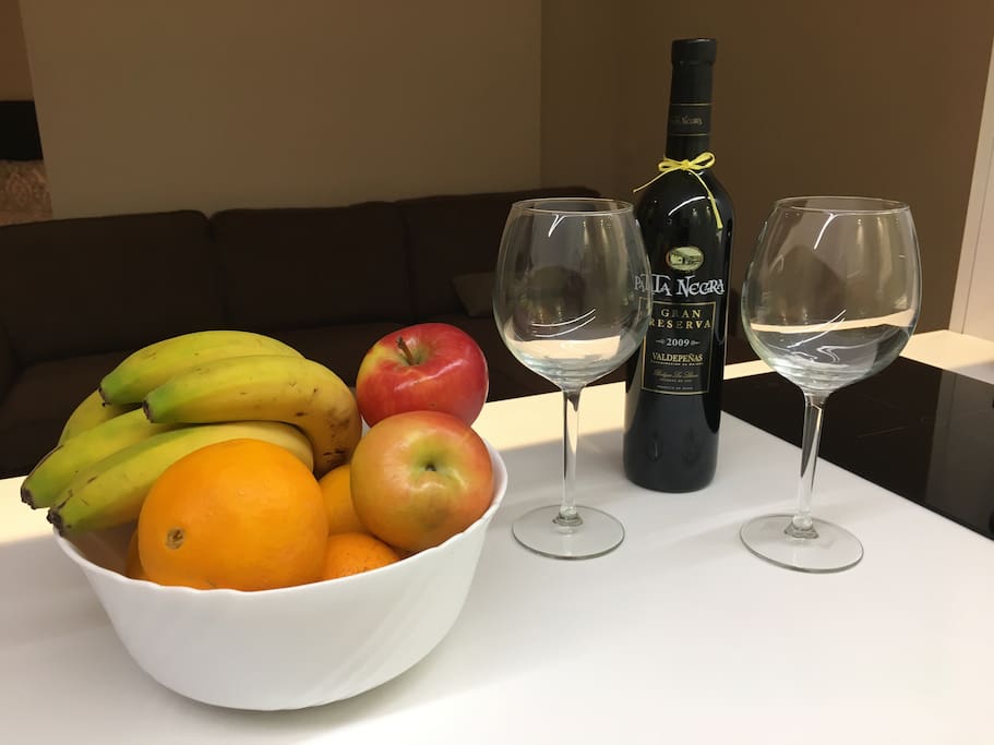 Bien venida, cesta de frutas y botella de vino
