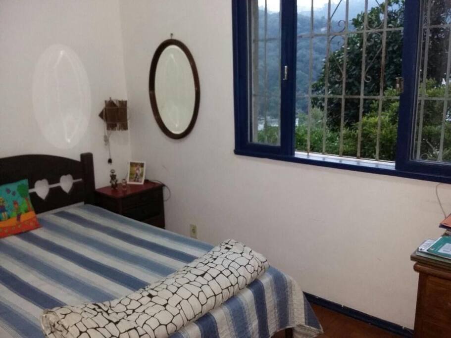 quarto com cama de casal, vista para o verde