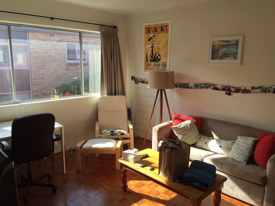 Sun drenched lounge room with fold out couch, TV and wifi.
