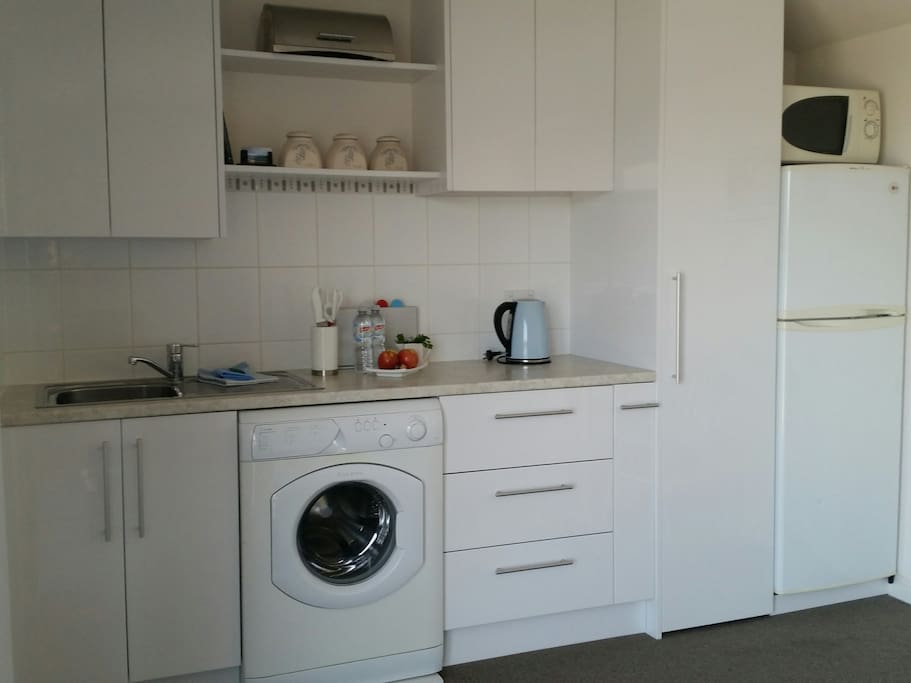 Kitchenette with sink, fridge,front loading washing machine,pantry,toaster,slowcooker,sandwhich maker, electric kettle,microwave, crockery & cutlery.
A double electric hotplate and small oven are available in cupboard for making light meals.