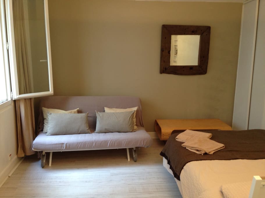 Living room with comfortable real bed and sofa bed
