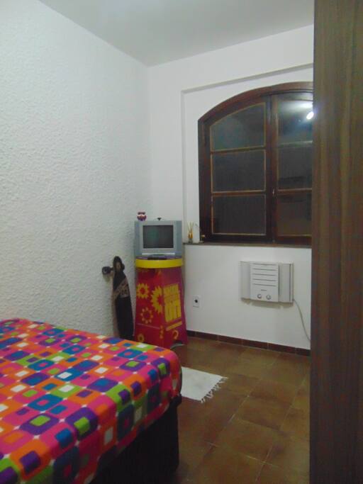 Quarto com TV e ar condicionado.