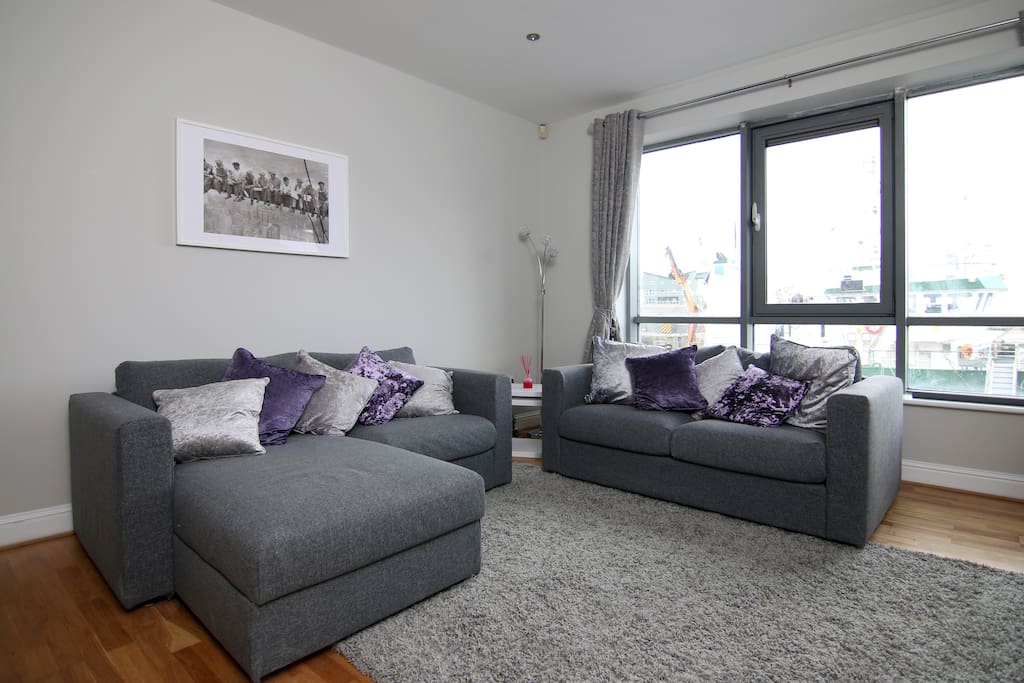 New comfortable seating to relax in after a day exploring the city. The living room has large windows, overlooking the marina and dock.