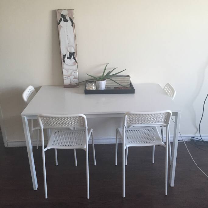 Dining table. Work station table with printer, lamp and bookshelf across from this.