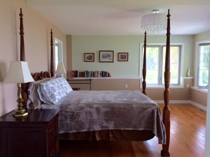 Dhomë gjumi master me dollap, televizor me ekran të sheshtë, pamje nga liqeni dhe banjë.