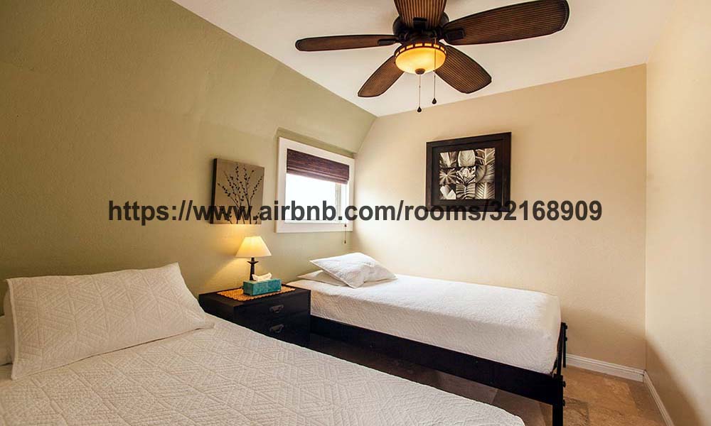 El segundo dormitorio tiene 2 camas individuales, un armario grande, aire acondicionado y una vista al mar junto con un ventilador de techo.