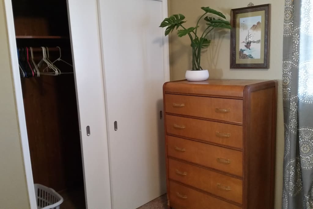 Spacious closet with hangers, laundry basket and iron