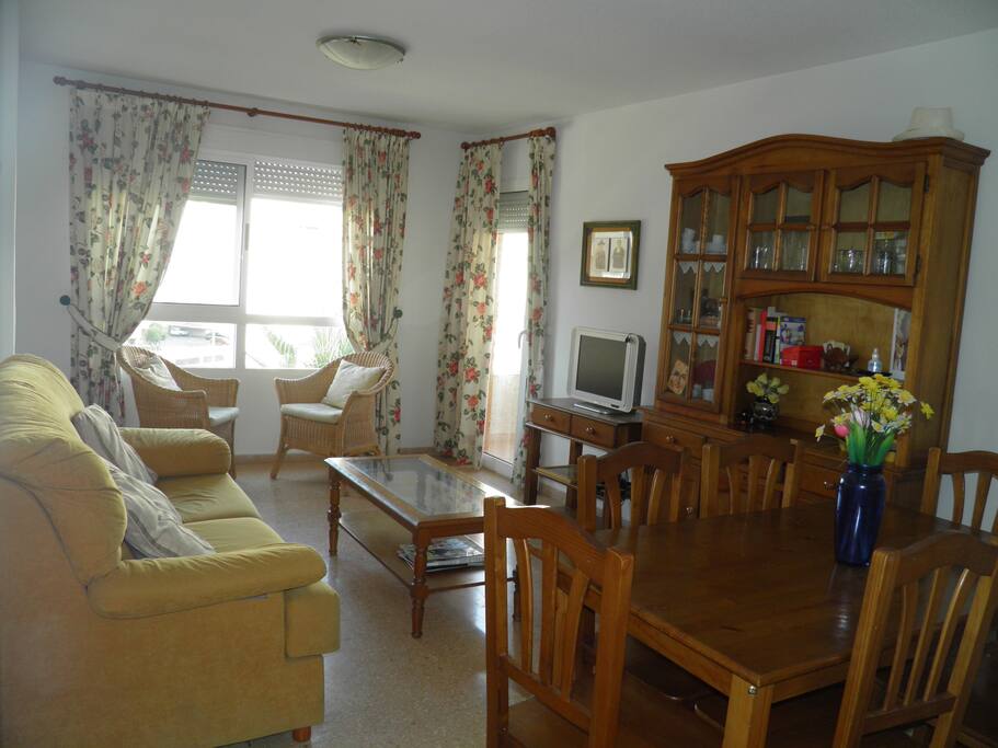 Salón con mesa de comedor para seis persona y acceso a la terraza